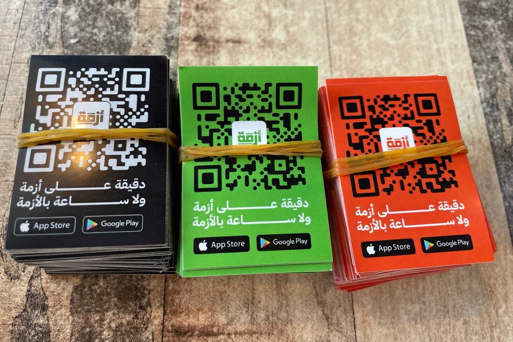 Cards with scannable QR codes to download the Azmeh app