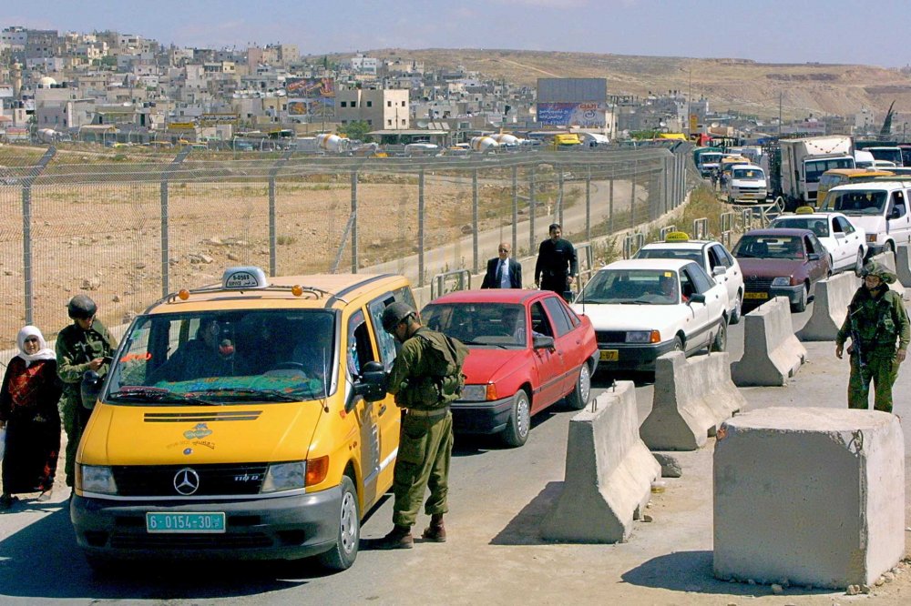 Qalandiya checkpoint between Jerusalem and Ramallah, with soldiers checking cars and a long traffic jam, 2006