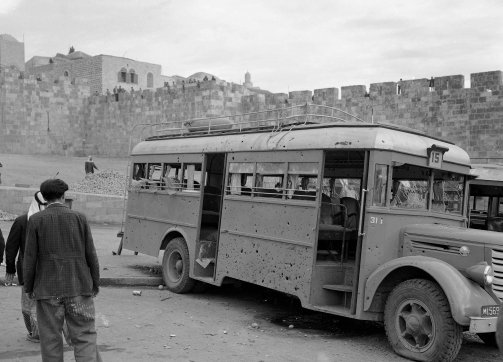 An Arab bus is peppered with shrapnel holes after two anti-personnel bombs explode near Damascus Gate, December 13, 1947