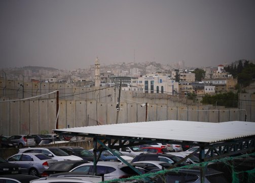 Visitors to al-Karawan Restaurant in Bethlehem park in a lot surrounded by the Separation Wall, 2021