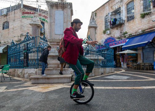 Ahmad Ju‘beh rides his unicycle in an East Jerusalem square.