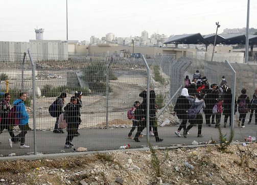 Palestinian students on their way to school pass through the Shu’fat military checkpoint in East Jerusalem on November 17, 2012.