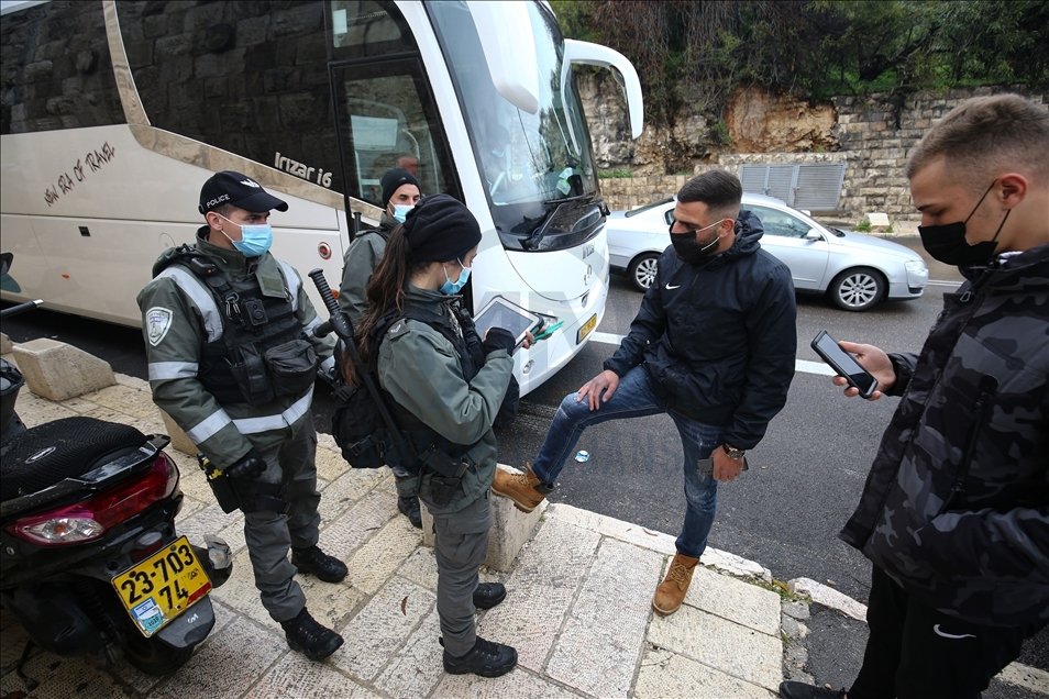 Israeli police in Jerusalem check a Palestinian's ID card on an iPad