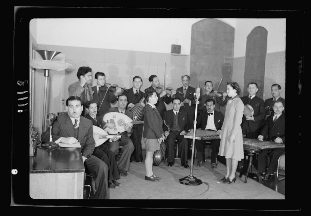 Girl and boy soloists sing at microphone of the Palestine Broadcasting Services, Jerusalem