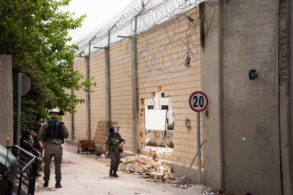 Israeli soldiers patrol the Separation Wall where Palestinian protesters broke through it