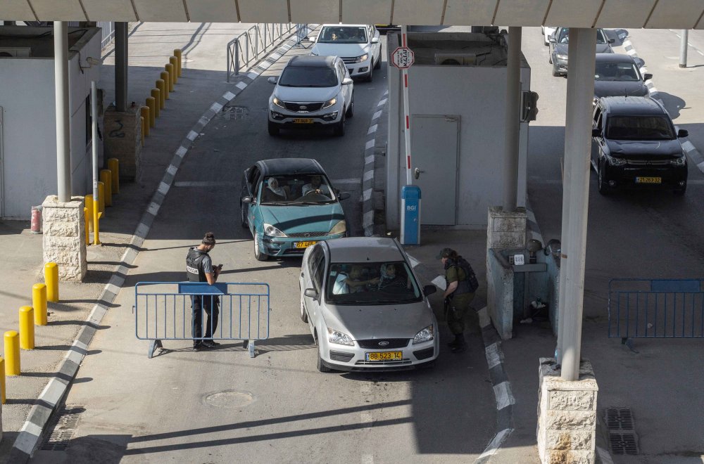 Israeli soldiers check cars passing through Qalandiya checkpoint