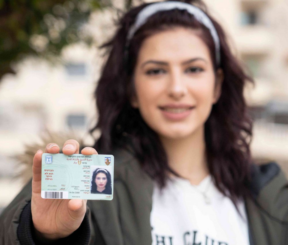 A Palestinian displays a magnetic card that stores biometric data allowing her or preventing her from accessing Jerusalem