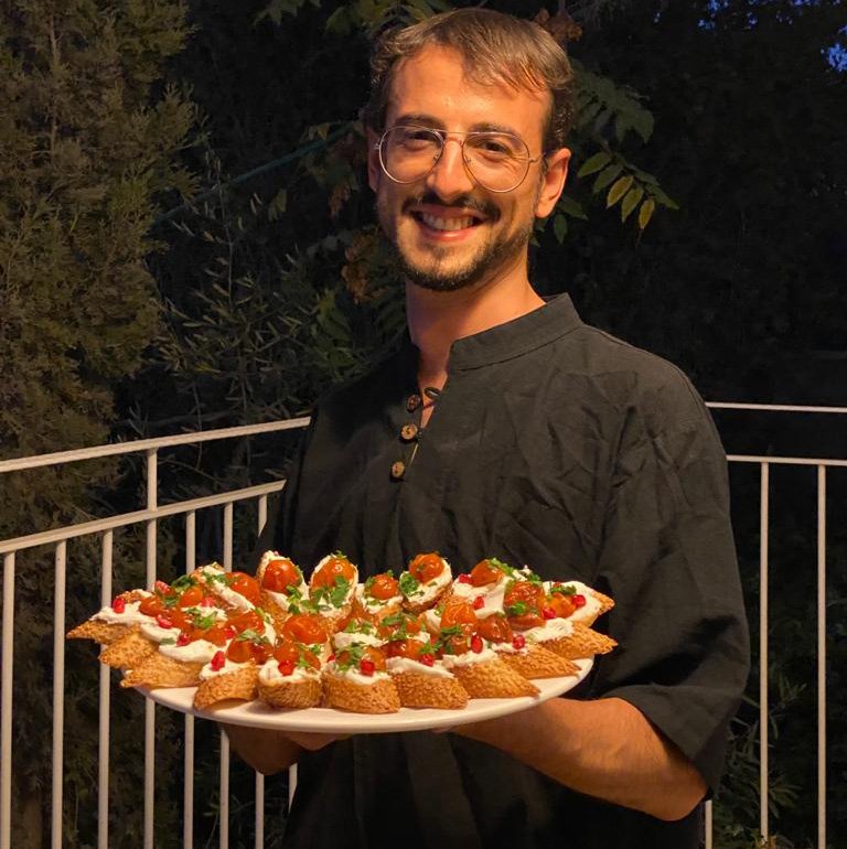 Sufi chef Izzeldin Bukhari holding a platter of crostinis with labneh