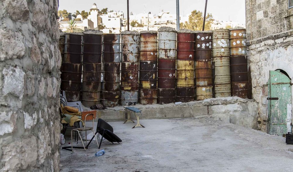 An Israeli barrier erected from barrels to block Palestinian travel on a West Bank road