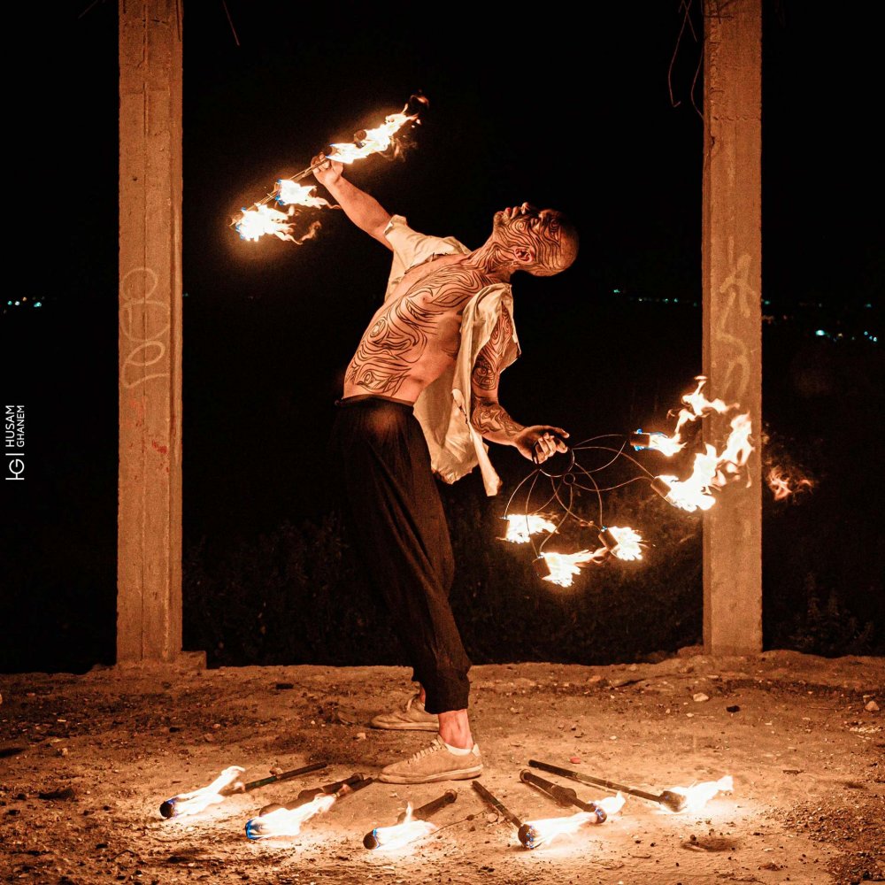 Palestinian artist Naromar performs a form of flow art with fire in Jerusalem