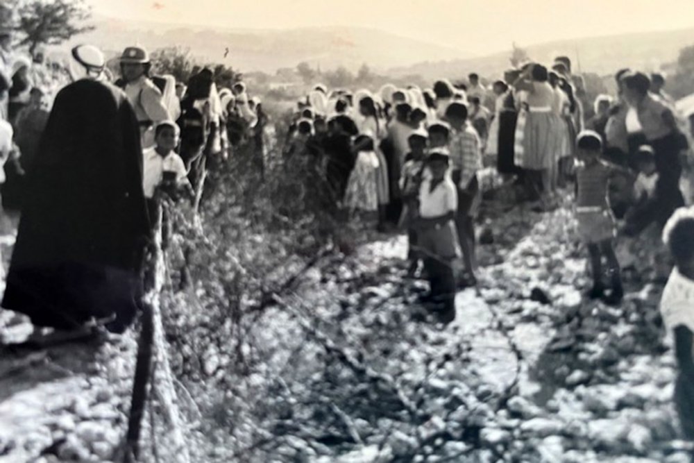 A funeral held on both sides of the Jerusalem armistice line marked by barbed wire, 1960