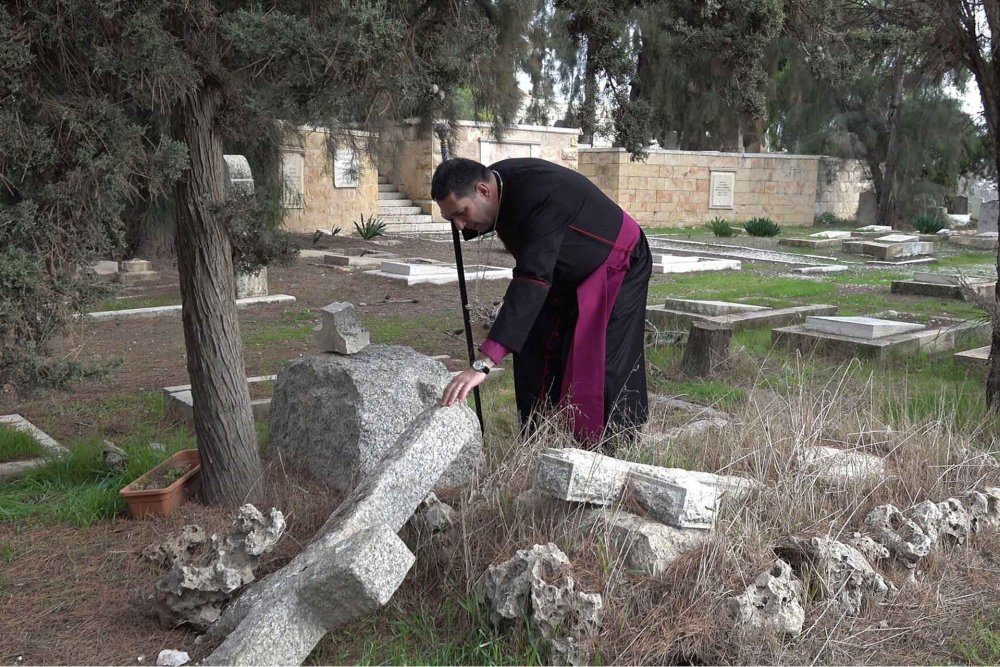 Anglican Archbishop Hosam Naoum inspects vandalized graves in the  Mount Zion cemetery, Jerusalem, January 4, 2023.