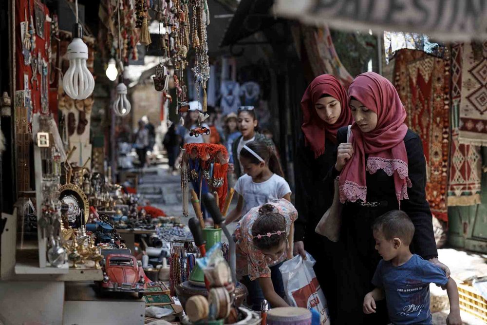 Muslim women and their children browse wares at Old City shops.