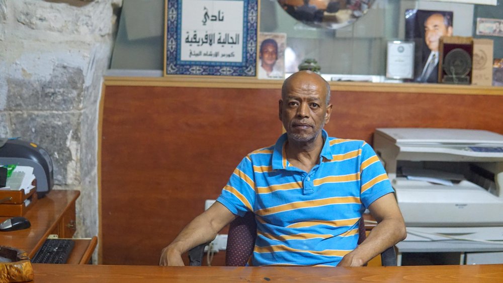 Mousa Qous sits at his desk at the Afro-Palestinian Community Center in Jerusalem's Old City, August 21, 2023.