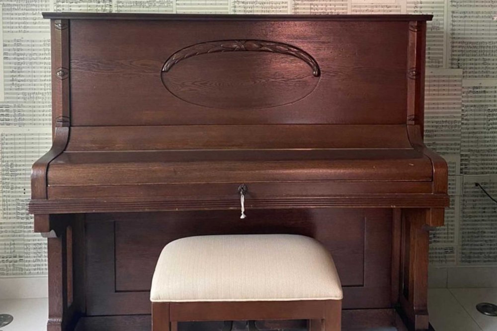 The piano of Palestinian Jerusalemite world-renowned composer Salvador ‘Arnita, against a against a background of 95 handwritten pages of the full orchestration of his Canata, “Identity”