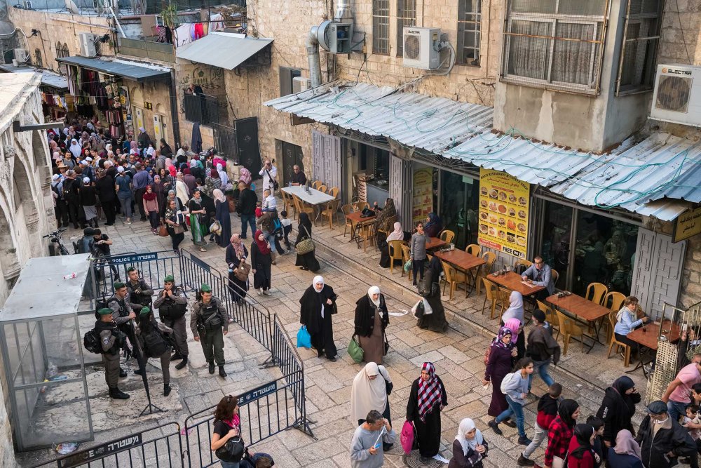 Israeli police monitor movement in Jerusalem’s Old City, surrounded by barricades, across from a Palestinian restaurant. 
