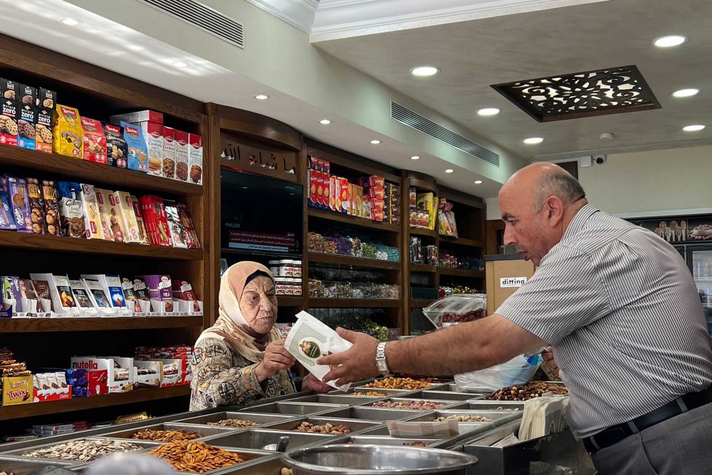 Abu Zaki al-Samman waits on customers at his nut shop