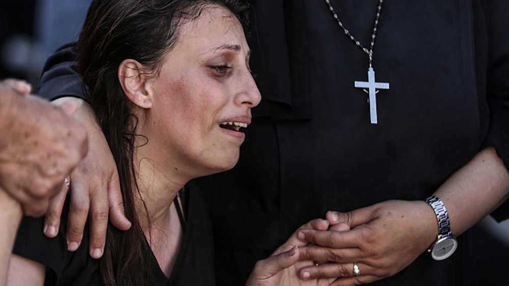 Palestinian woman mourns the loss of loved ones after an Israeli strike on Greek Orthodox Saint Porphyrius Church in Gaza killed 18 Palestinians who were sheltering there, October 20, 2023.