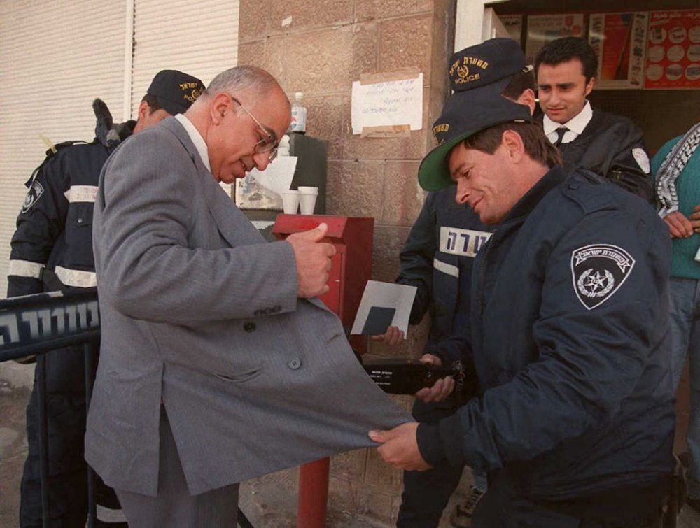 Israeli police check a Palestinian voter at an Israeli post office in East Jerusalem, January 20, 1996.