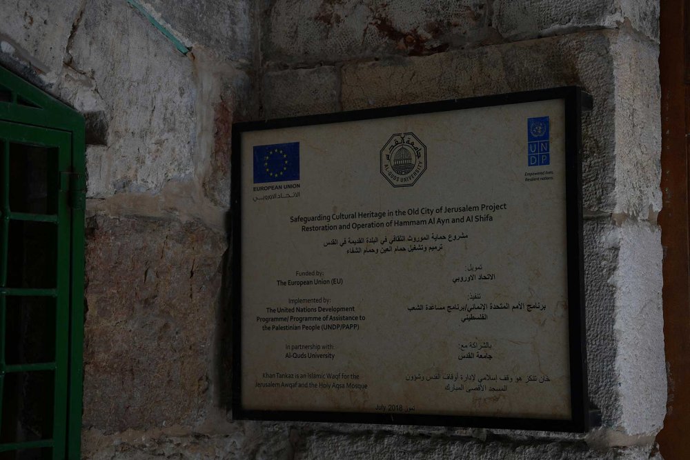 A sign identifying the EU-funded restoration project at the ancient archeological site where Al-Quds University has its center in Jerusalem.