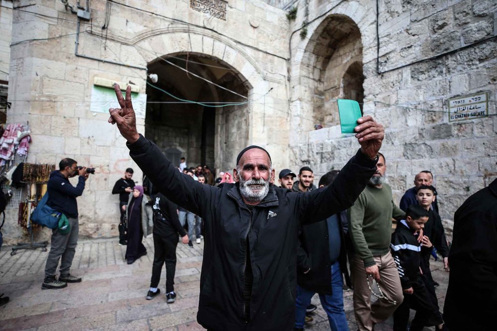 An elderly Palestinian man from the West Bank flashes a victory sign celebrating having prayed at al-Aqsa Mosque during Ramadan, March 15, 2024, after months of Israeli closure.