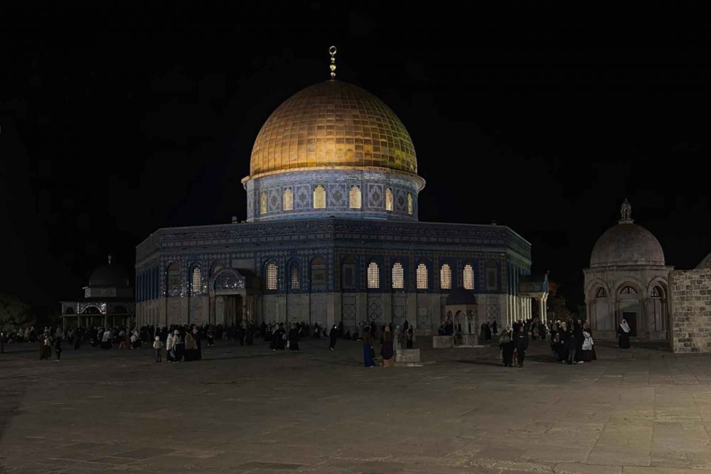 al-Aqsa Mosque in Jerusalem at night, its gold dome glittering