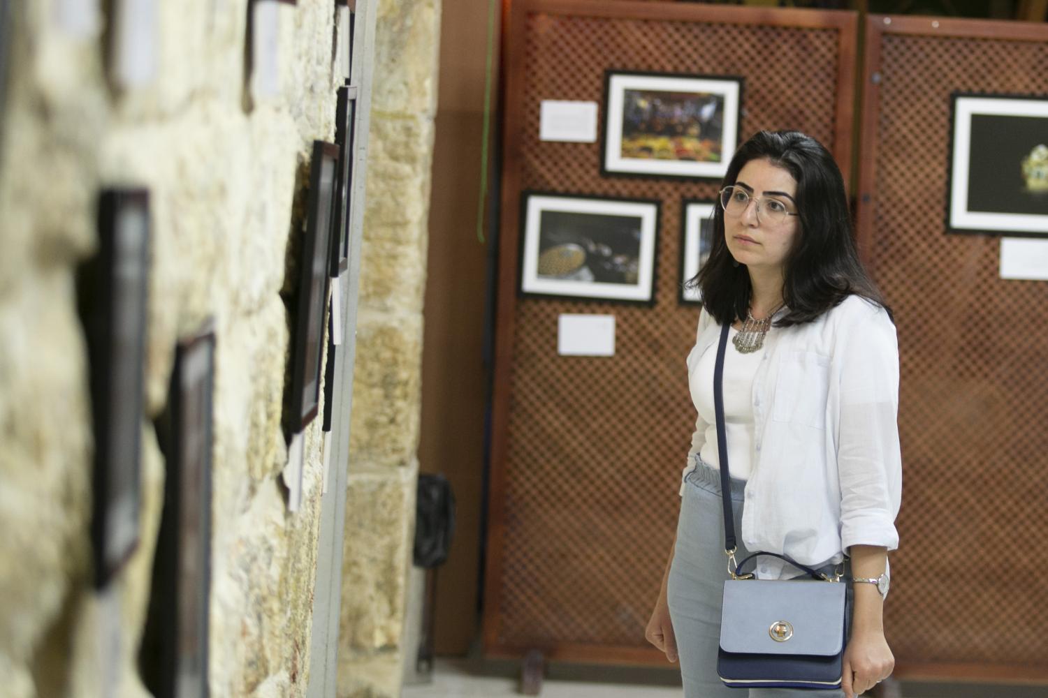 A visitor looks at photos of Middle Eastern markets at the African Community Society in the Old City of Jerusalem
