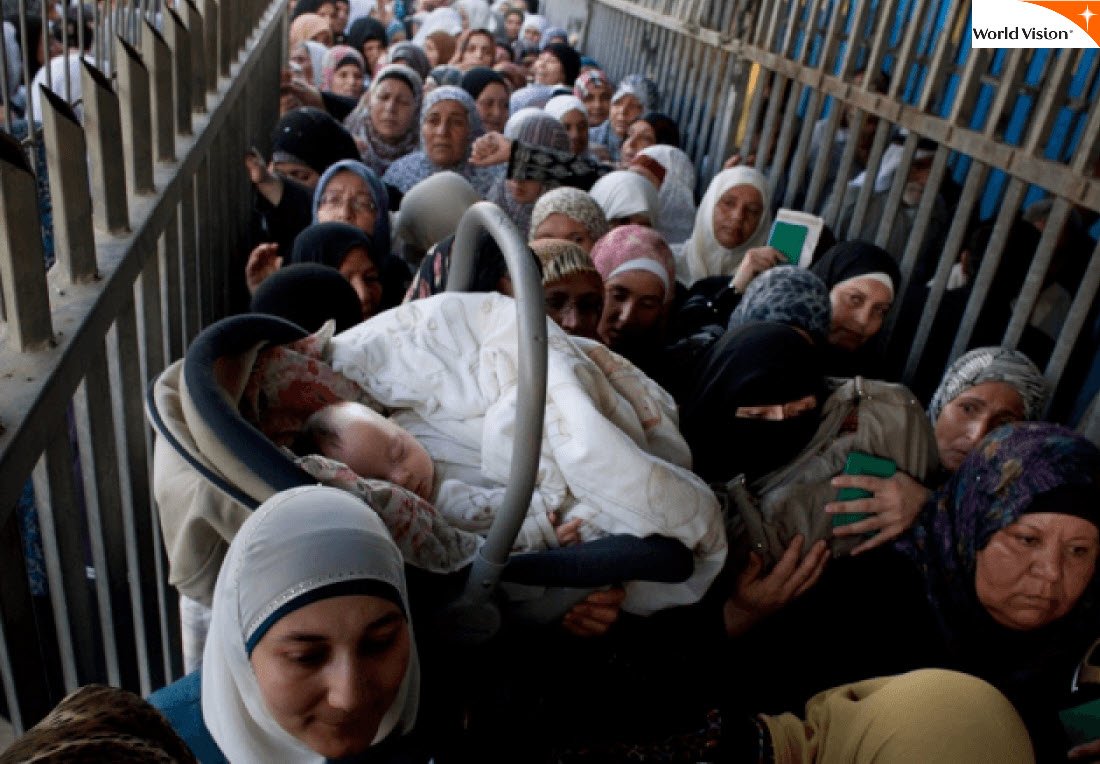 An infant queues with her mother to cross Qalandiya checkpoint, 2012