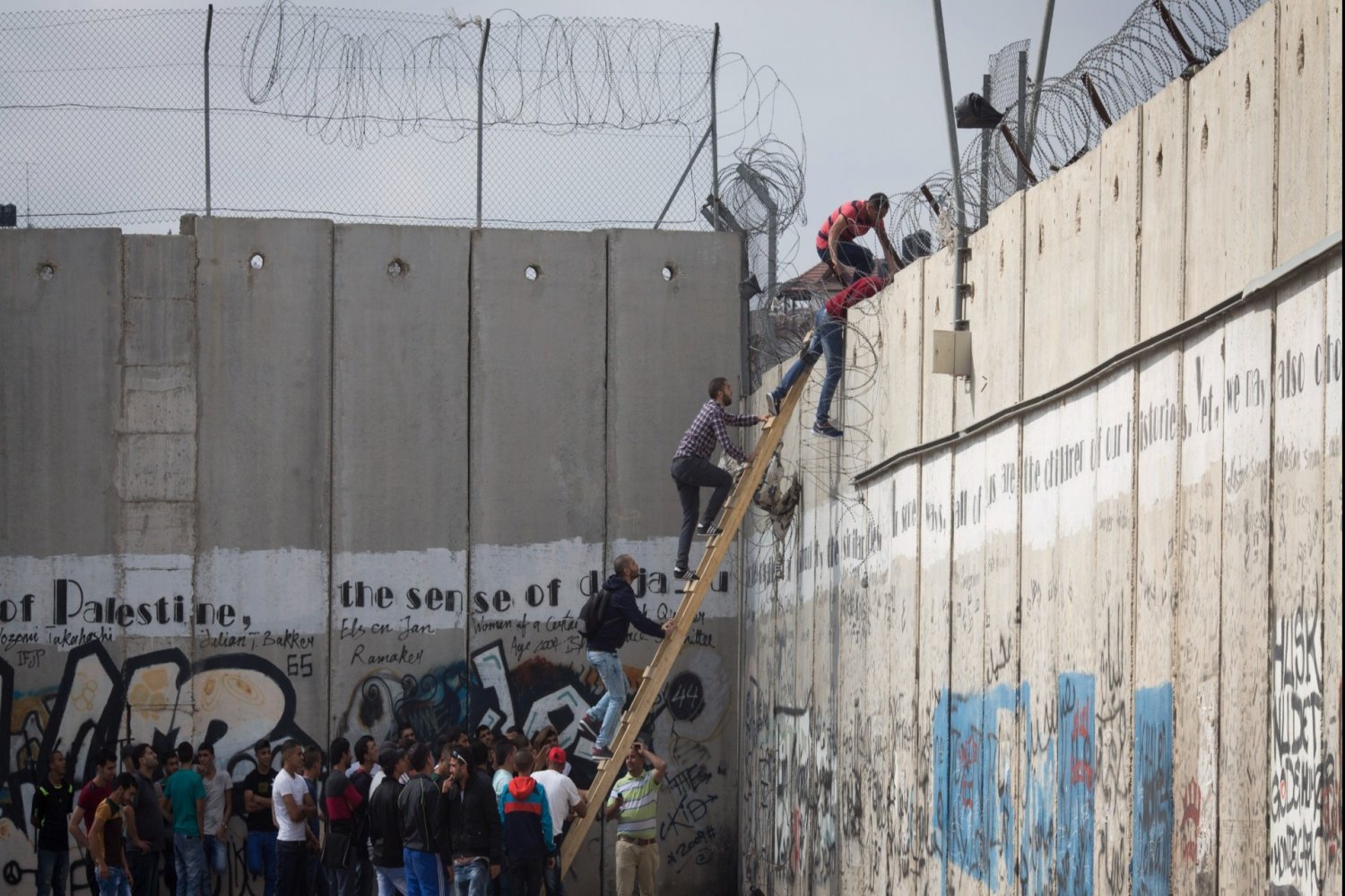 Palestinians use a ladder to circumvent the closure and enter Jerusalem without permission