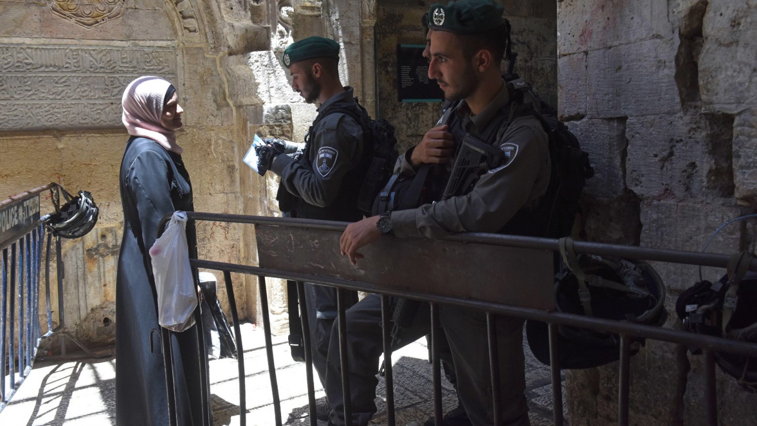 An Israeli border policeman checks the ID card of a Muslim woman leaving the al-Aqsa Mosque.