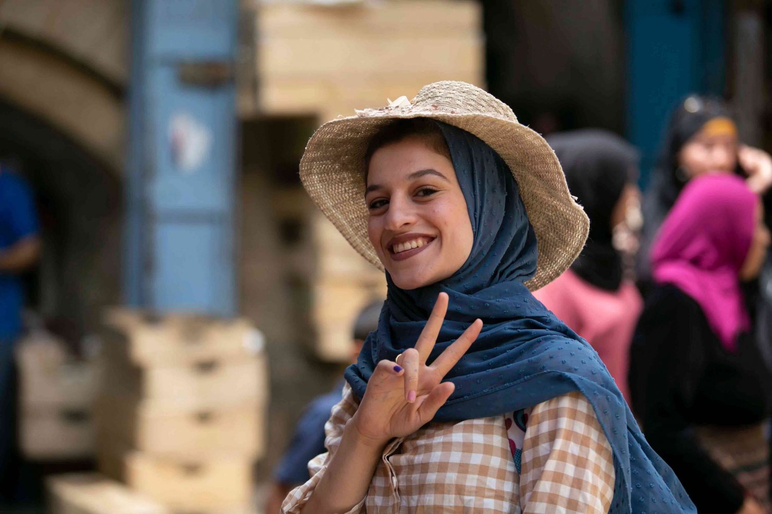 A woman flashes a victory sign as she passes by in the Old City of Jerusalem, 2021