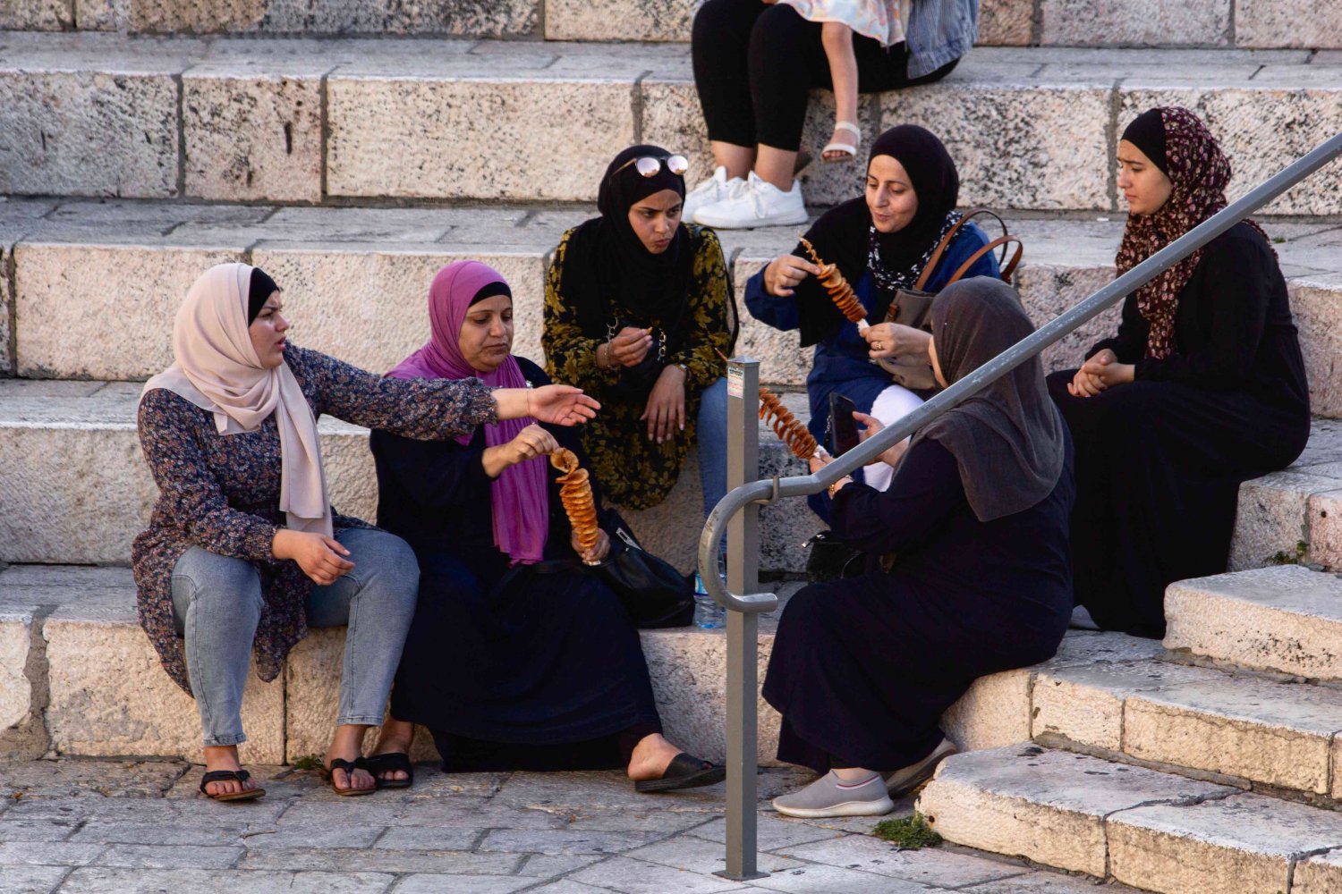 A group of women friends enjoy some chips together on the steps of Bab al-Amud in East Jerusalem, 2021