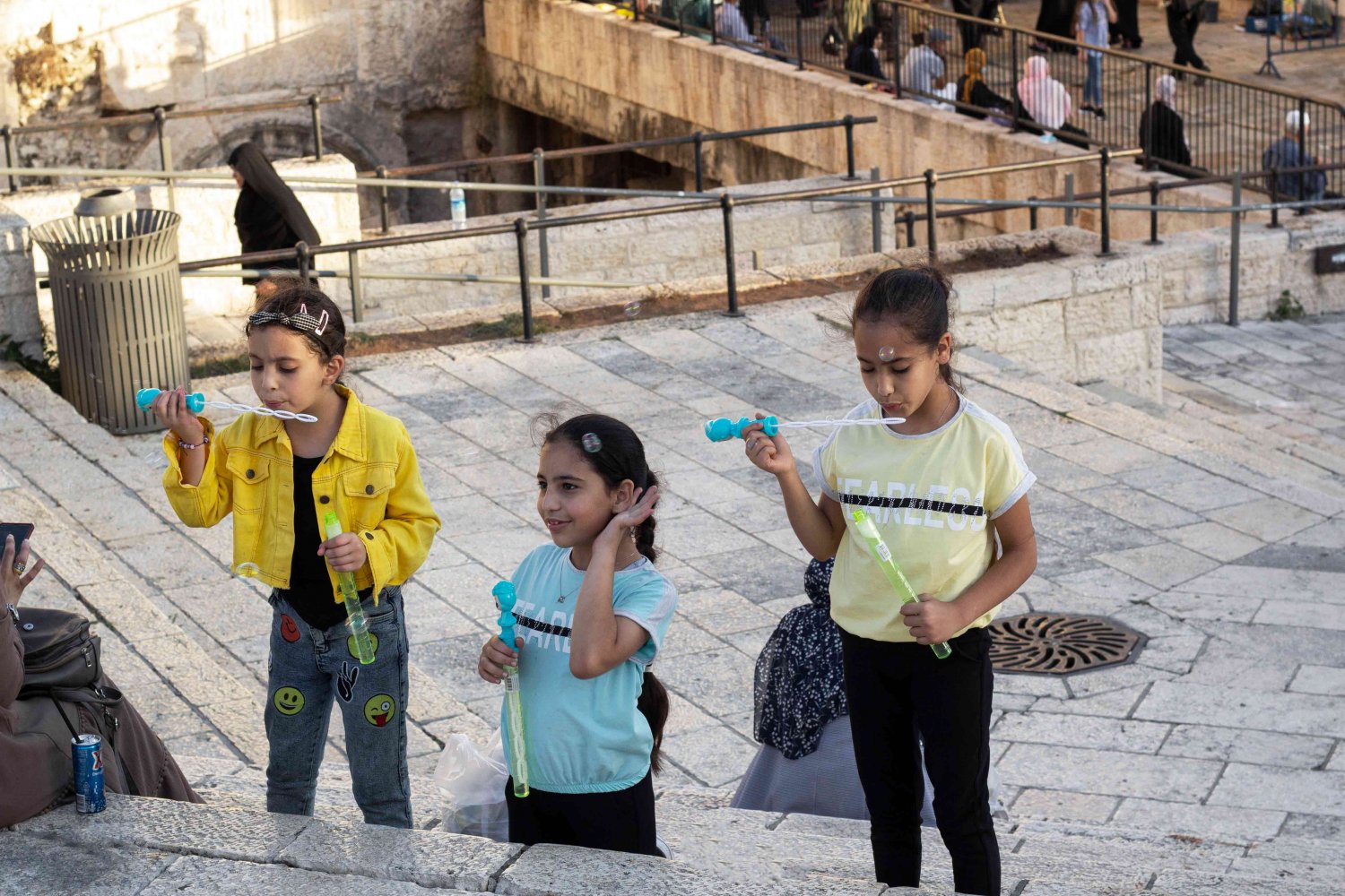 Girls blow bubbles on the steps in front of Bab al-Amud in East Jerusalem, 2021
