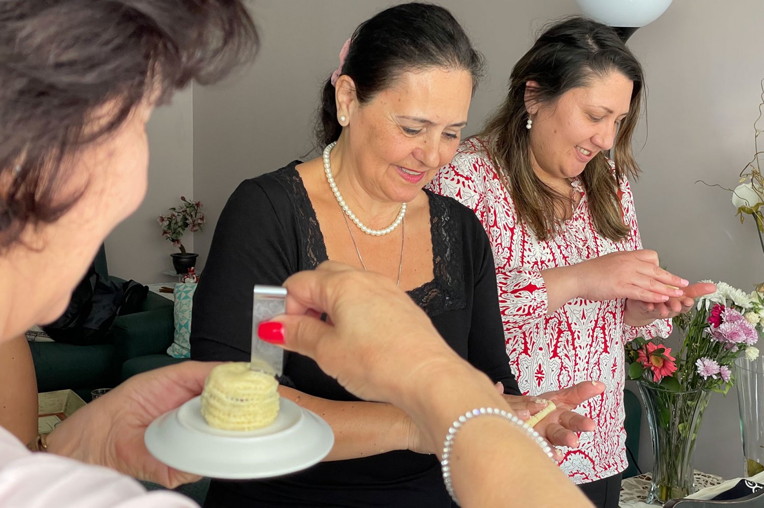 Three Palestinian women shaping and decorating ma'moul Middle Eastern pastries