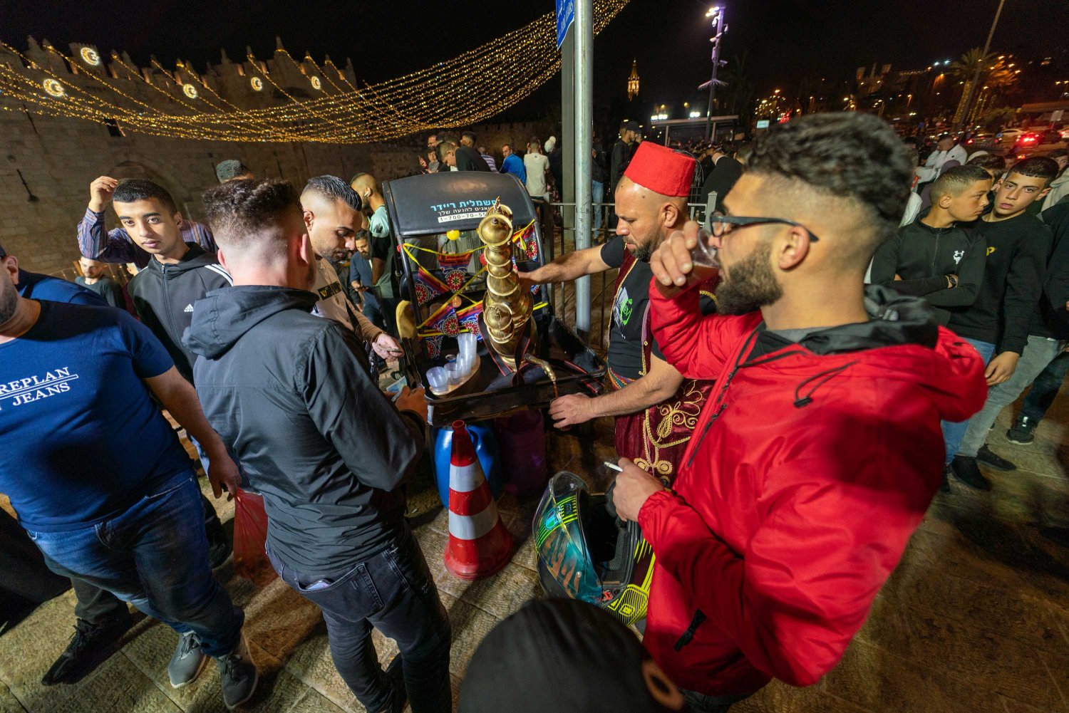 Palestinian youth drink coffee outside Damascus Gate/Bab al-Amud at the entrance to the Old City of Jerusalem in Ramadan 2022