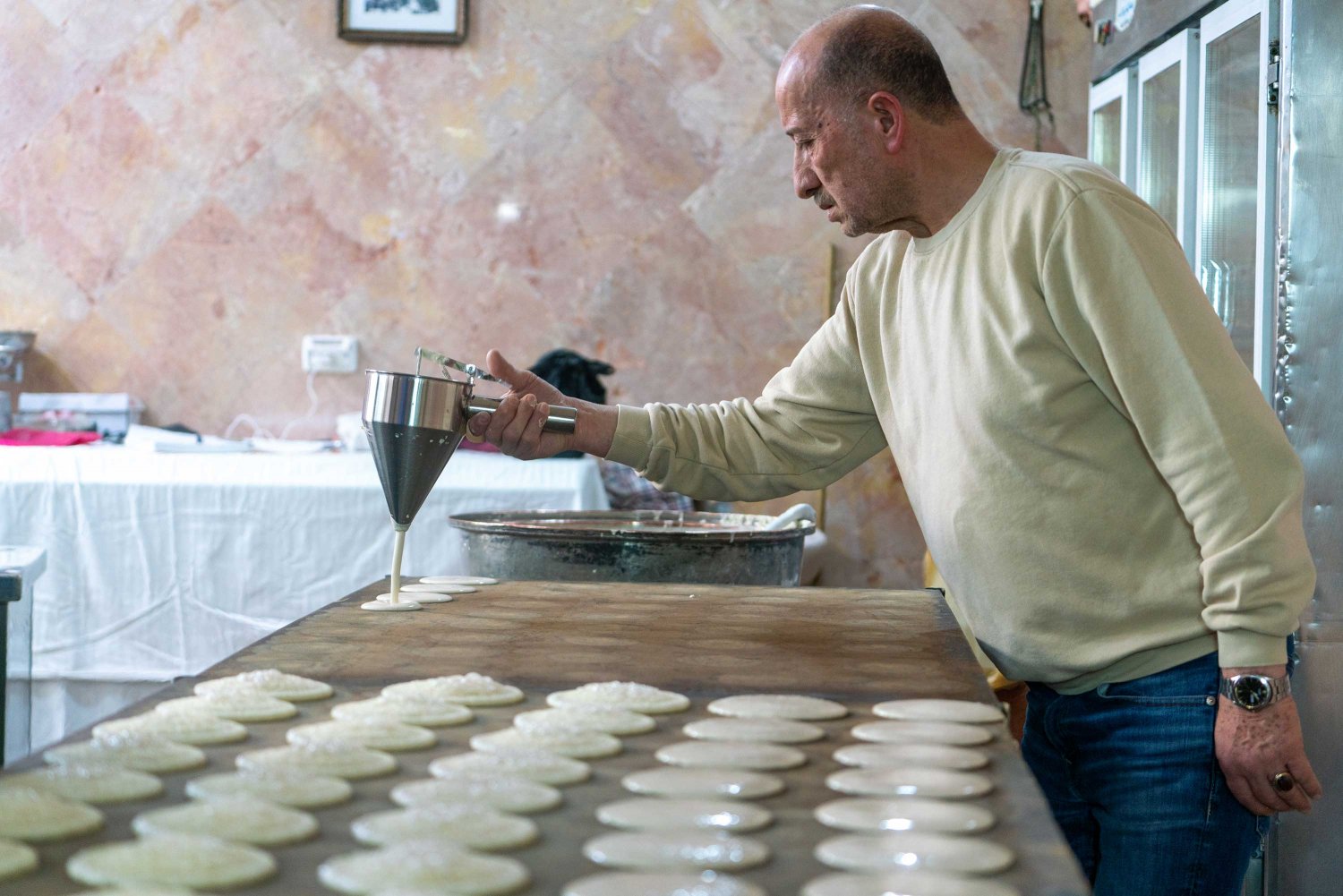 A Jerusalem Old City vendor prepares qatayef, a sweet pancake stuffed with cheese or walnuts, during Ramadan 2022