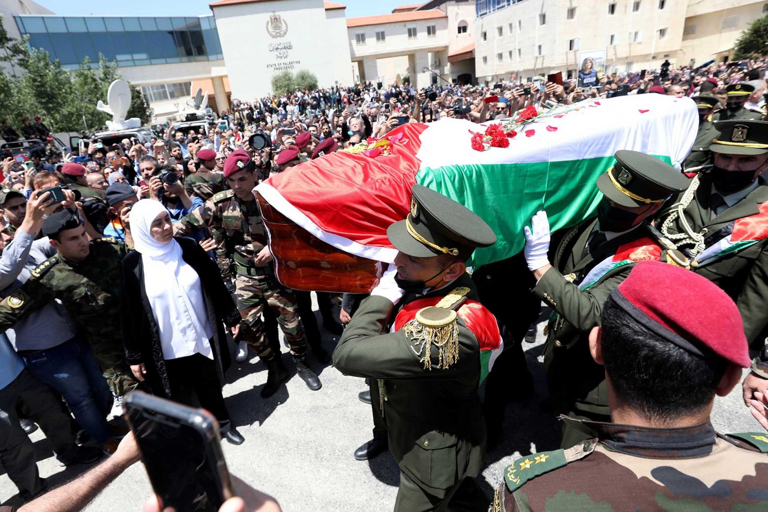 A Palestinian honor guard carries the coffin of Shireen Abu Akleh at the Palestinian Authority headquarters in Ramallah