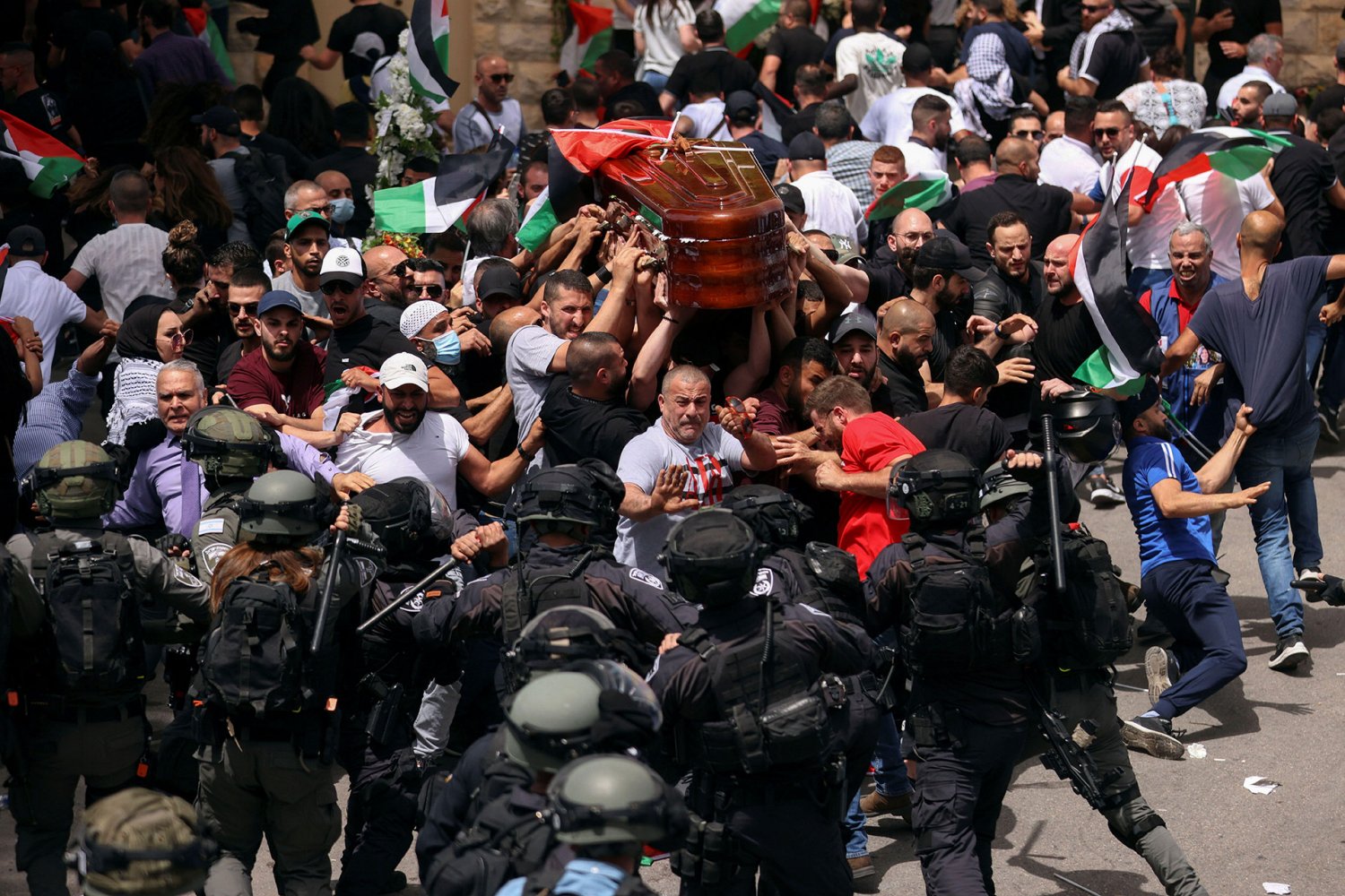 Israeli police beat back Palestinians bearing Shireen Abu Akleh’s coffin as it leaves St Joseph Hospital in East Jerusalem