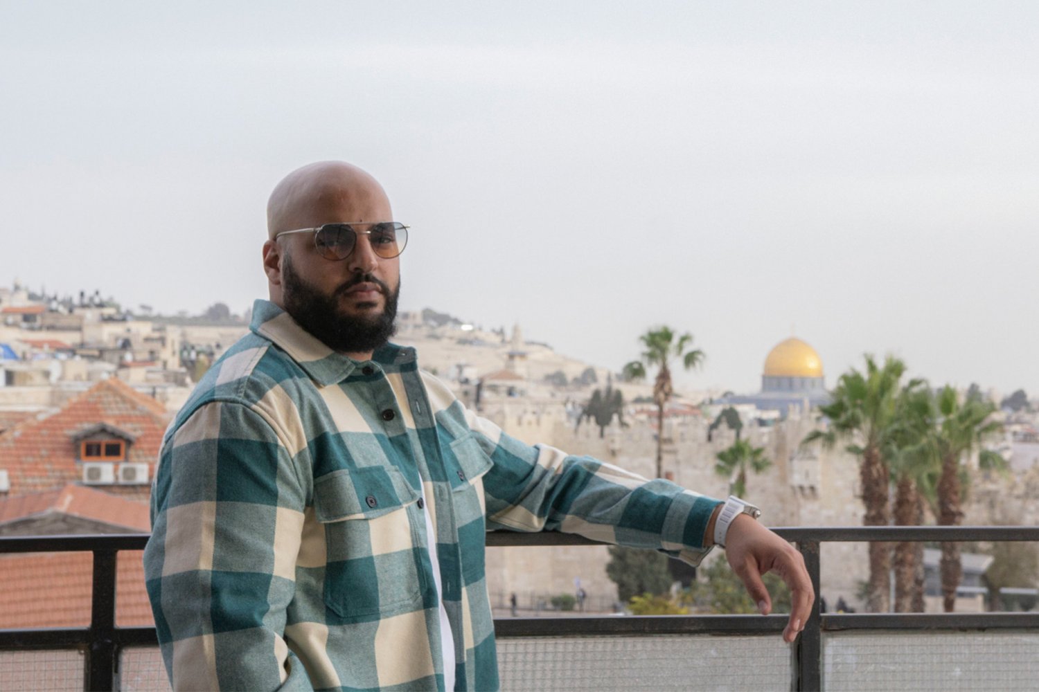 Arabic rapper Ahmad Abu Baker looks out at Jerusalem's Dome of the Rock