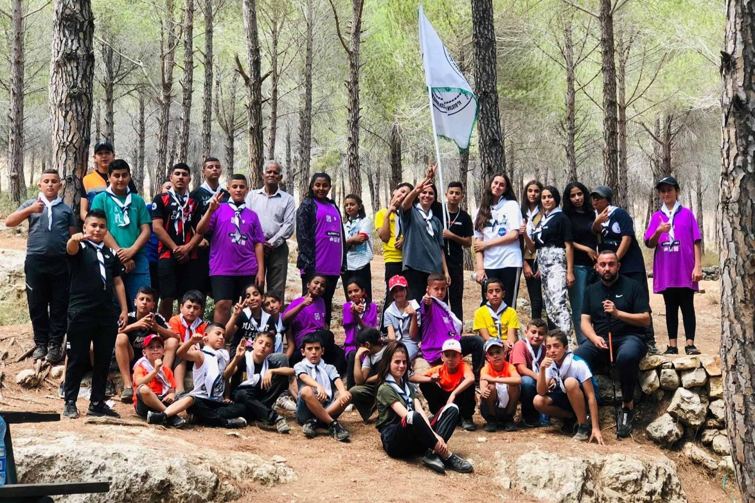 Youth from Jerusalem's Silwan neighborhood gather in a woods for summer camp