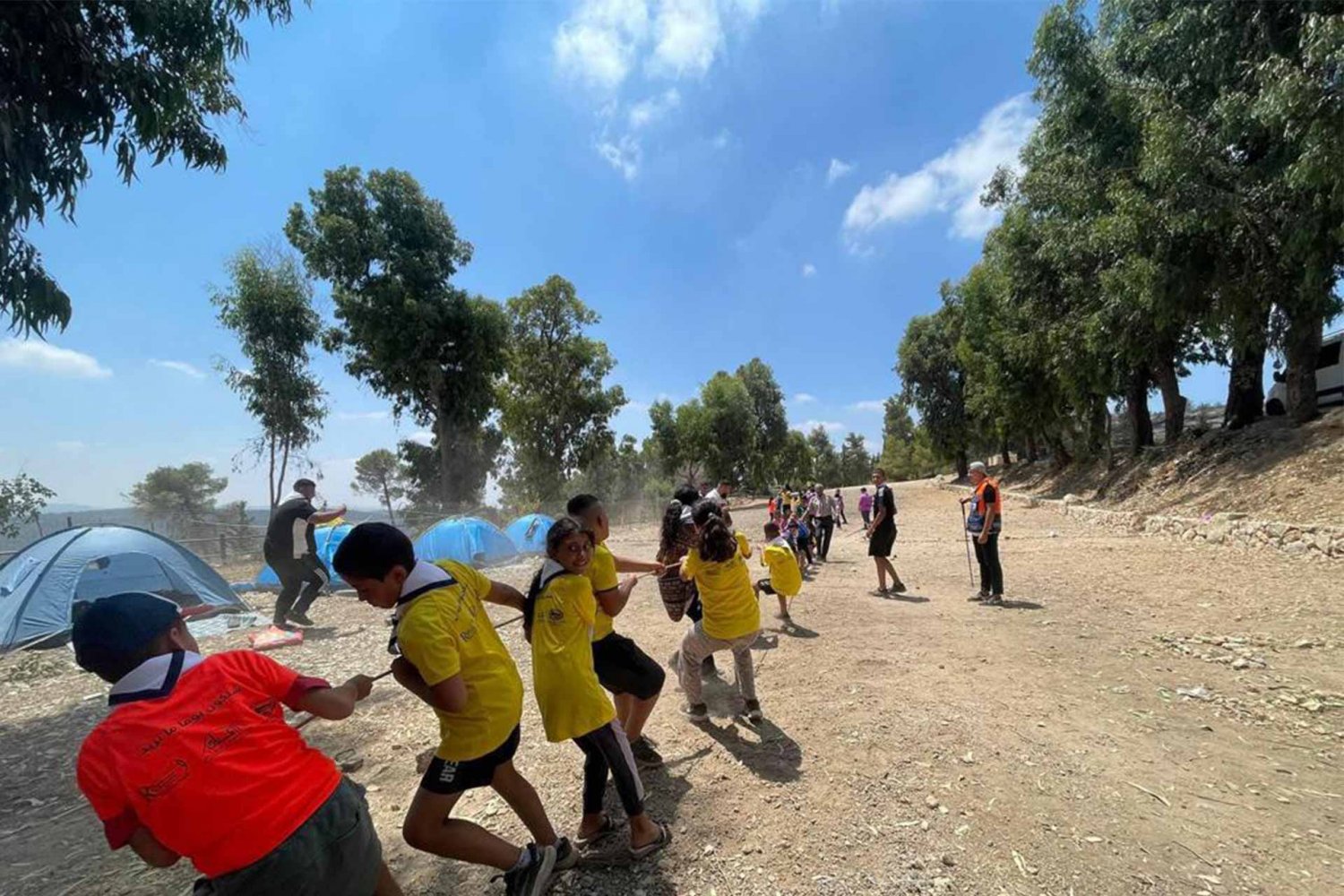 Campers engage in a tug-of-rope competition during “Silwan Summer 2022,” a youth camp for the al-Bustan district scout group