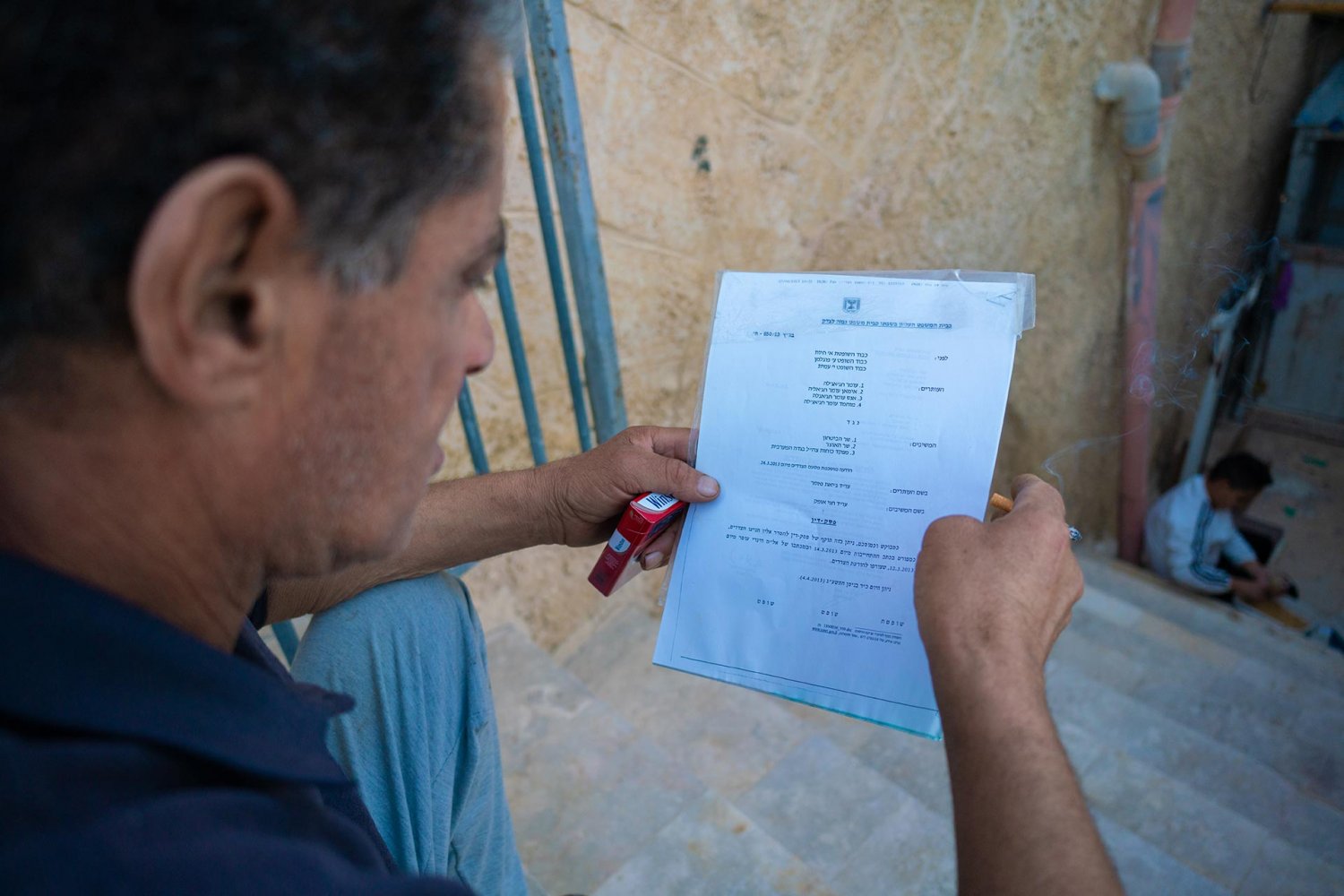 Omar Hajajla holds a 2013 Israeli Supreme Court order promising a tunnel to replace the fence around his al-Walaja home.
