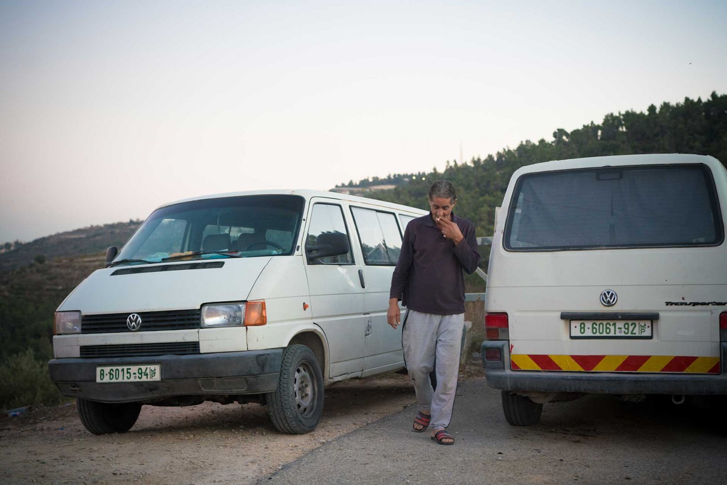 Omar Hajajla with vans he uses to take children to a nearby school because no school can be built in the al-Walaja ghetto.