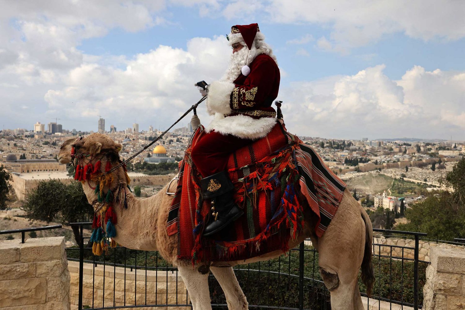 Jerusalem’s Santa Claus sits on a camel looking over Jerusalem's Old City