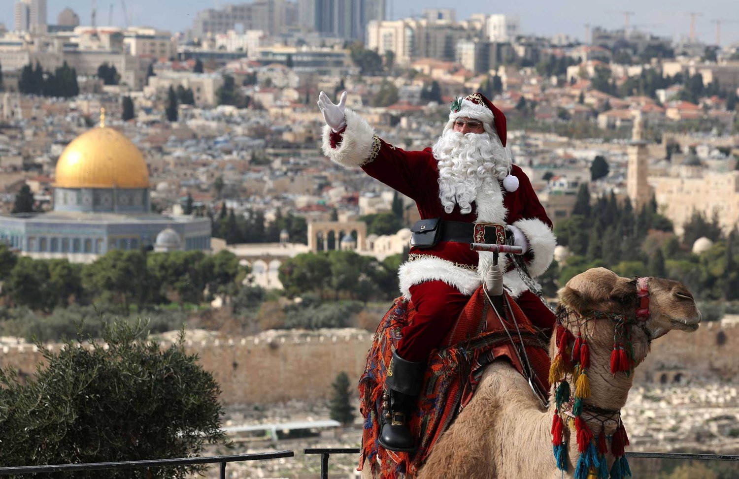 Jerusalem’s Santa Claus sits on a camel on front of the al-Aqsa Mosque compound