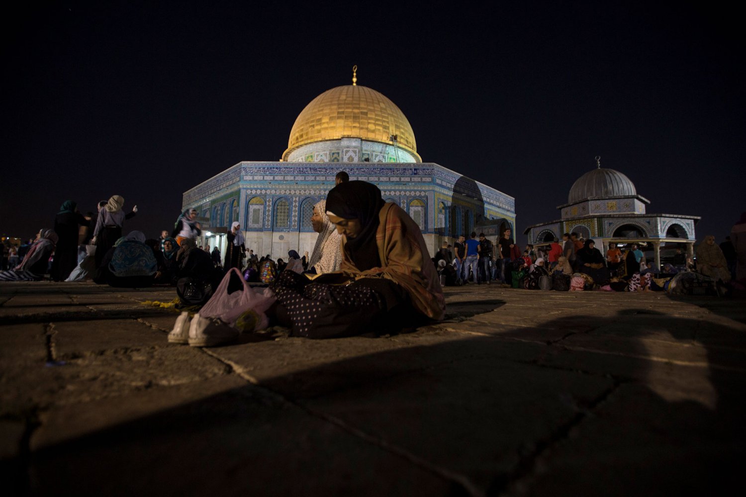 Women sit in the courtyard of al-Aqsa Mosque on the night believed to be Laylat al-Qadr, the holiest night of the year for Muslims, July 13, 2015.