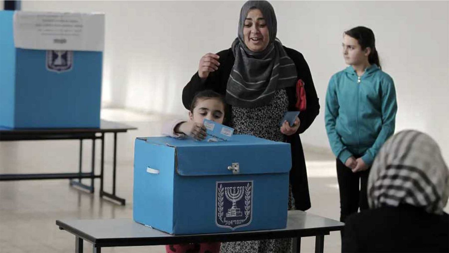 A Palestinian Jerusalemite votes with her child in the Jerusalem municipal elections, 2006