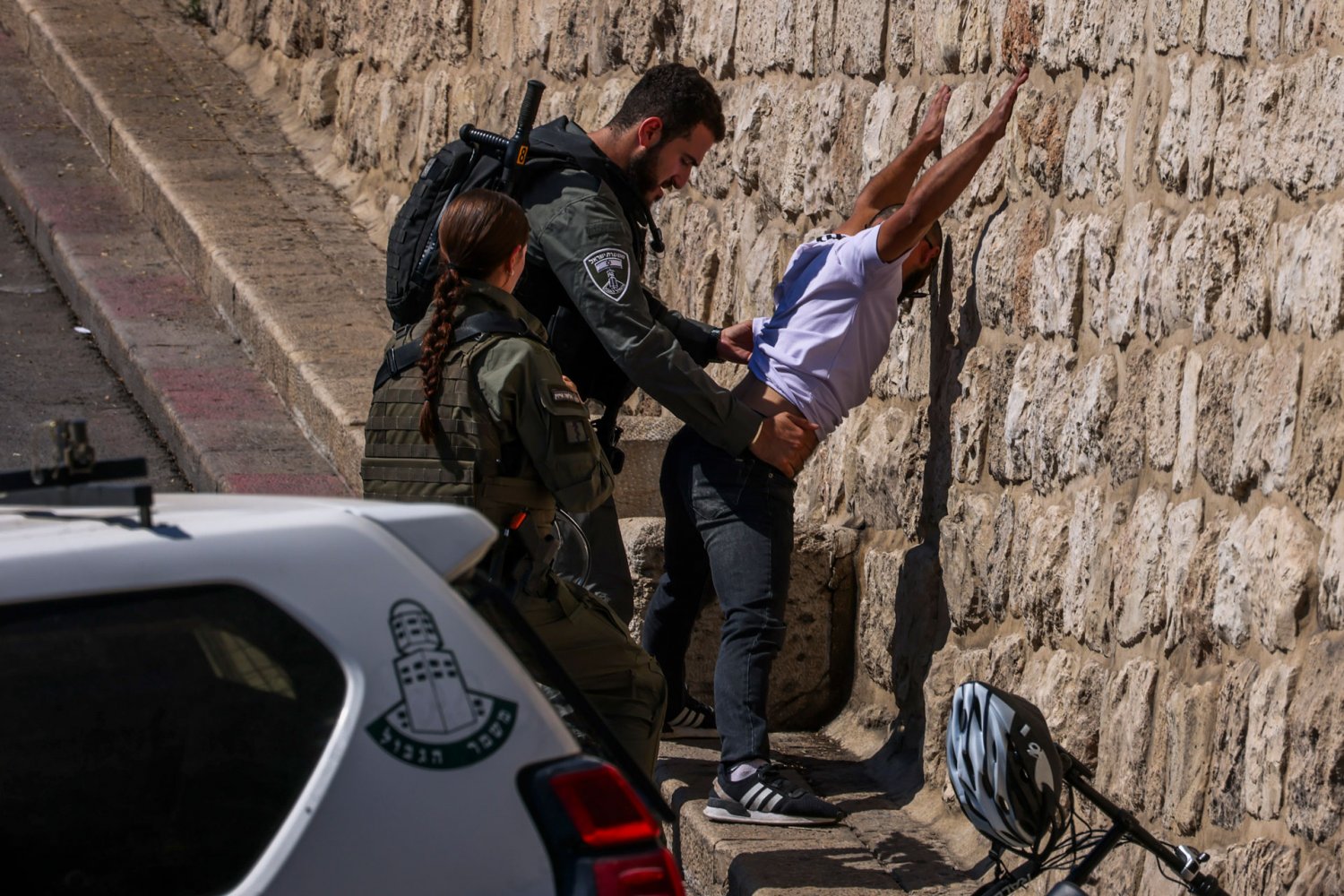 Israeli police search a Palestinian passerby in the Old City of Jerusalem on October 13, 2023.