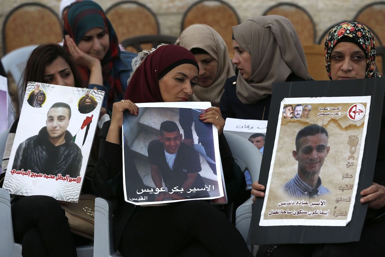 Palestinian women hold portraits of relatives in Israeli jails in support of a hunger strike by detainees, May 25, 2017.