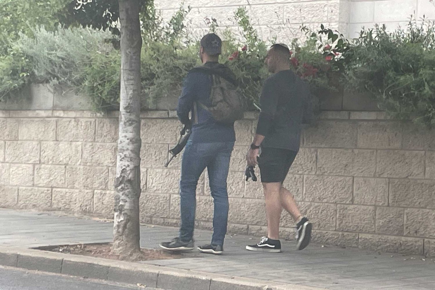 Armed Israelis walk in East Jerusalem, October 2023